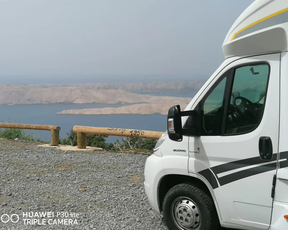 KFZ-Vermietung Hermann Wohnmobil an einer Küstenstraße mit Blick aufs Meer